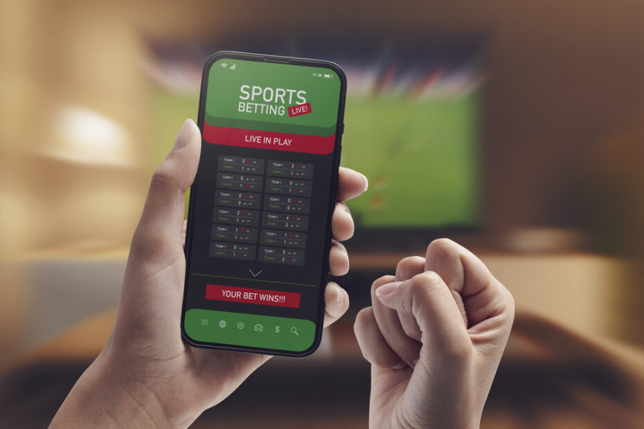 Live in-play betting app on smartphone display, a woman is betting at home and winning, POV shot